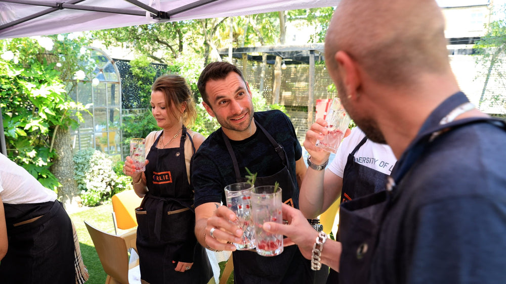 Guests raising a glass together at a Charlie Oven fish and seafood masterclass