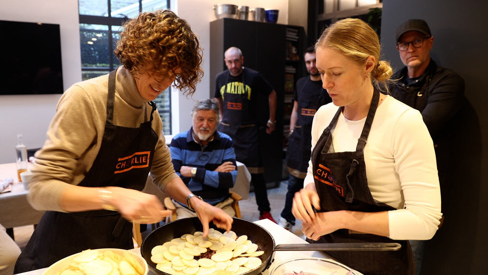Guests layering sliced potatoes during a Charlie Oven cooking masterclass