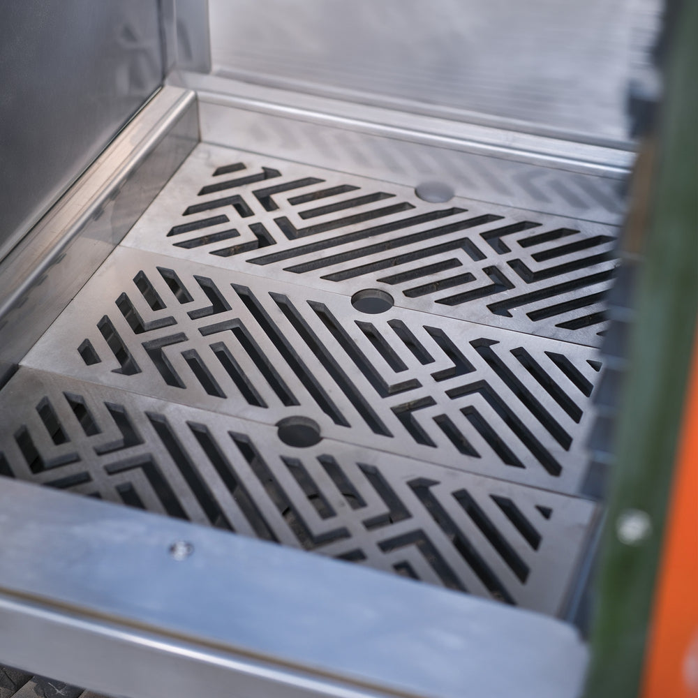 Patterned stainless steel charcoal grates with the Charlie signature design, fitted in a Charlie oven
