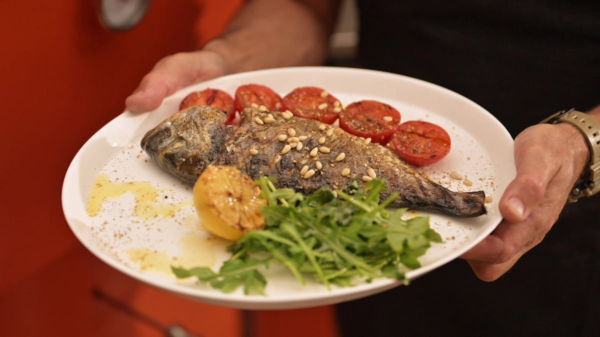 Grilled sea bream served with charred tomatoes and rocket