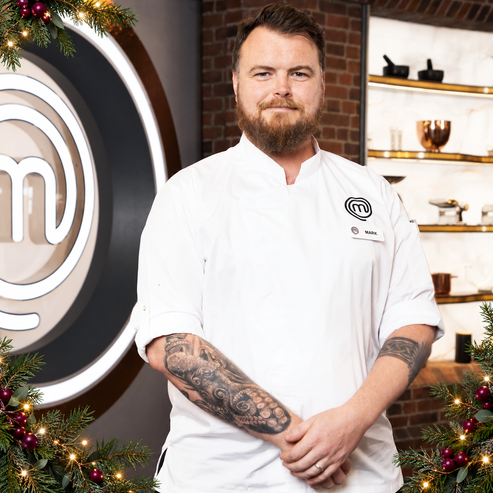 Mark O’Brien in his MasterChef chef’s jacket, framed with Christmas greenery and lights