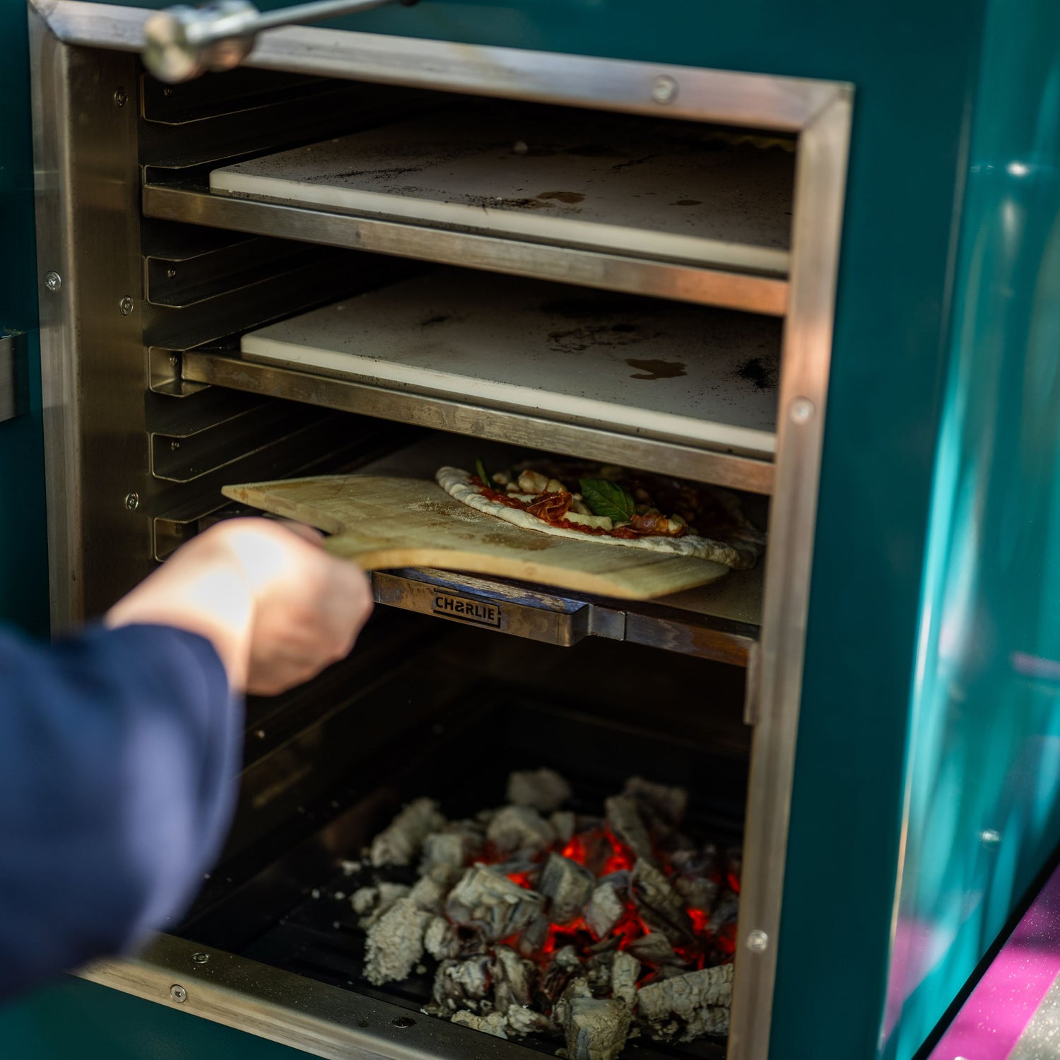 pizza placed inside the charlie oven to bake