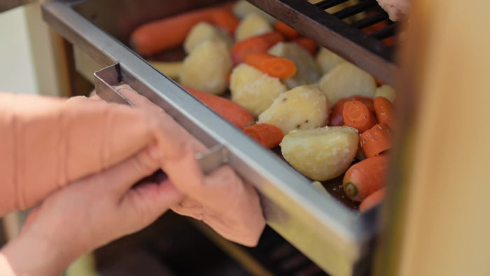Sliding the Deep Roasting Tray Rack onto a lower level of the Charlie Oven