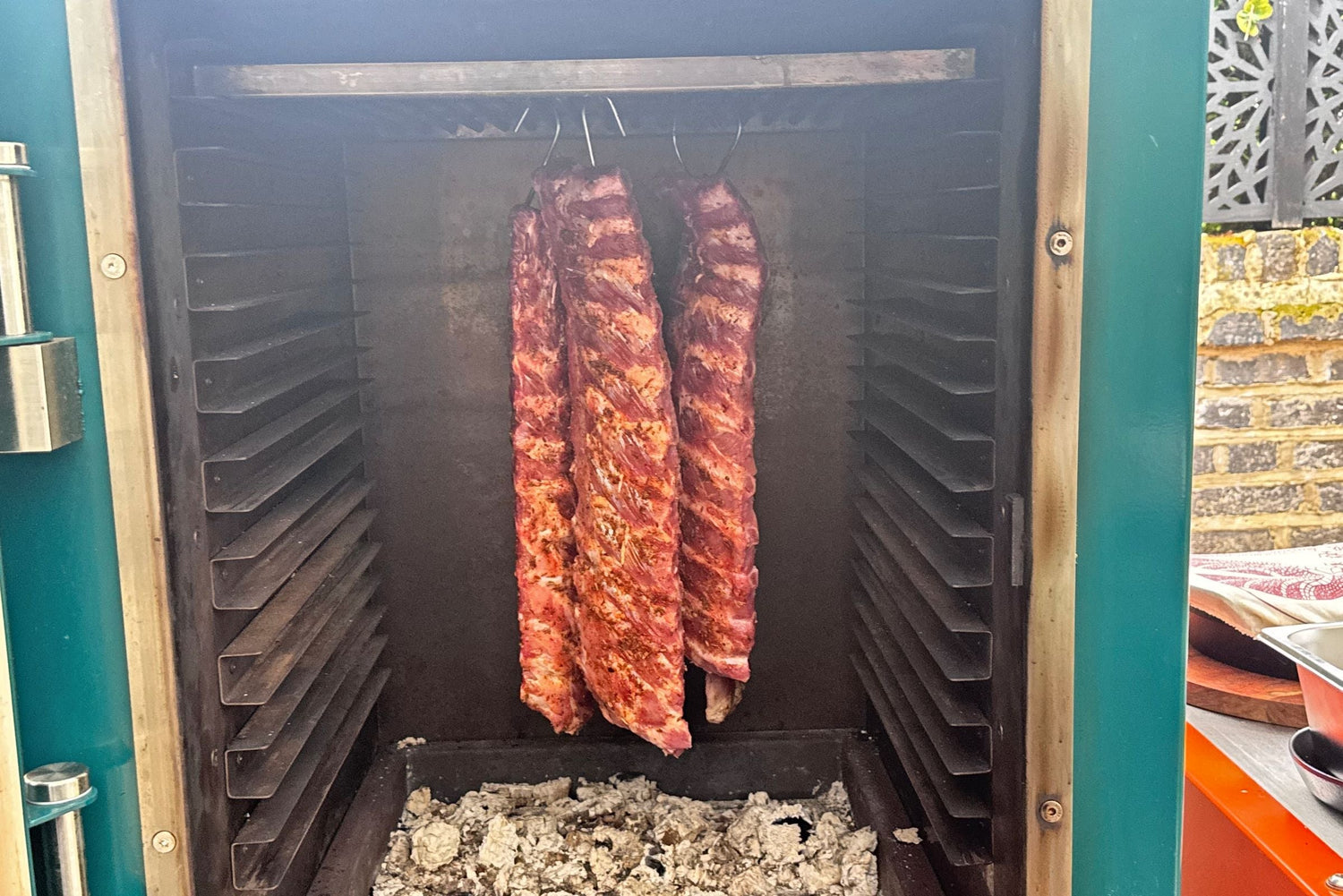 HANGING BBQ RIBS INSIDE THE CHARLIE OVEN TO SMOKE LOW AND SLOW BEFORE REMOVING TO BASTE WITH BBQ SAUCE