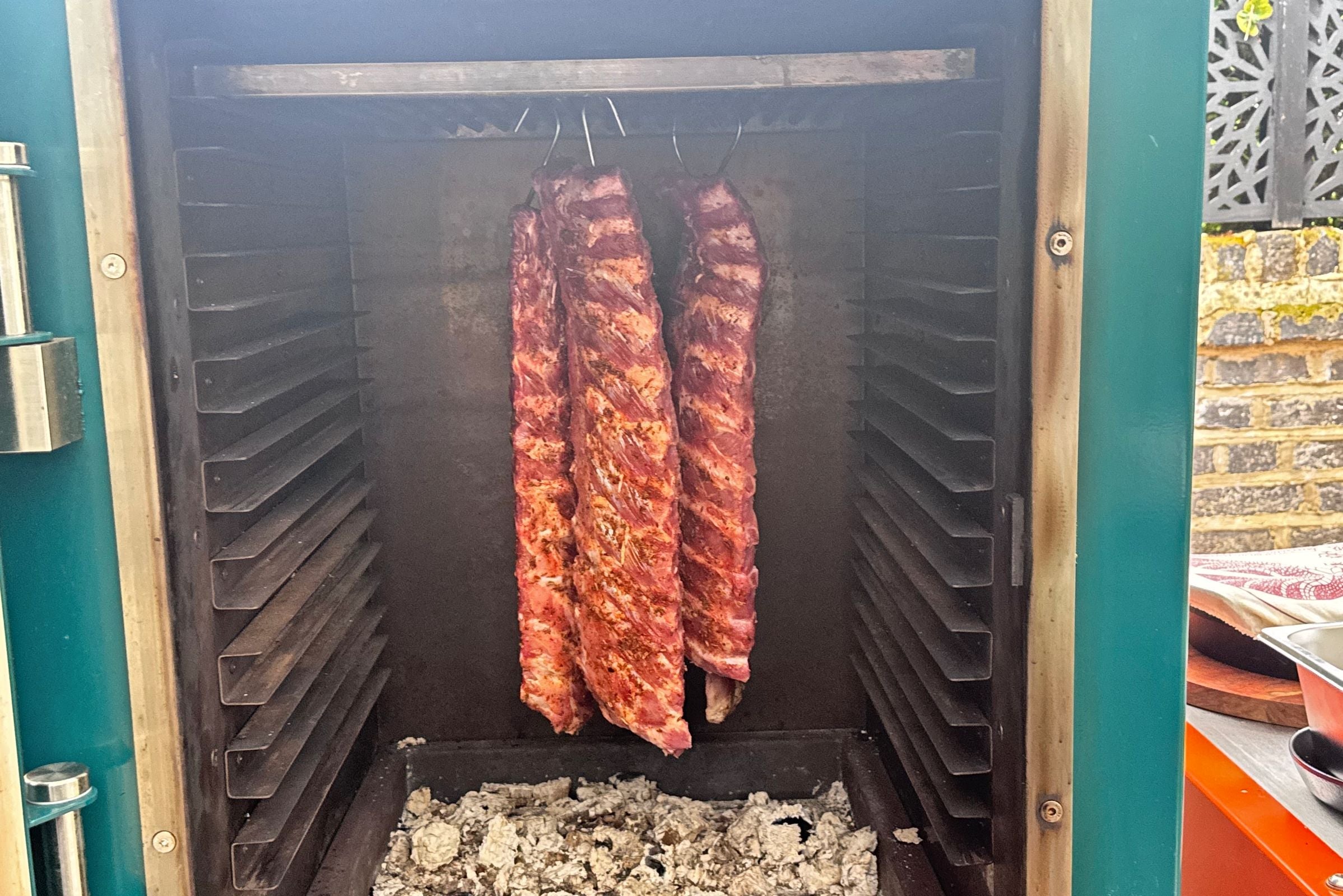 HANGING BBQ RIBS INSIDE THE CHARLIE OVEN TO SMOKE LOW AND SLOW BEFORE REMOVING TO BASTE WITH BBQ SAUCE