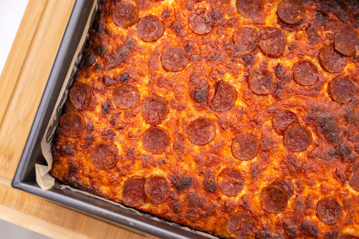 Detroit style deep dish pepperoni pizza cut into squares