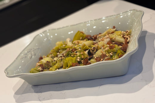 Ember baked leeks with Mangalitsa pork fat, burnt lemon and toasted pine nuts