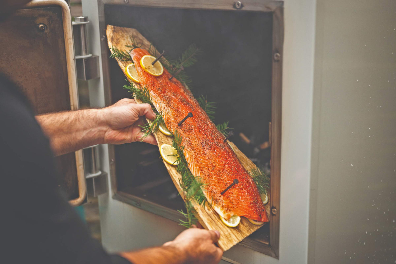 hot smoked salmon placed on a cedar board ready to smoke in the charlie oven
