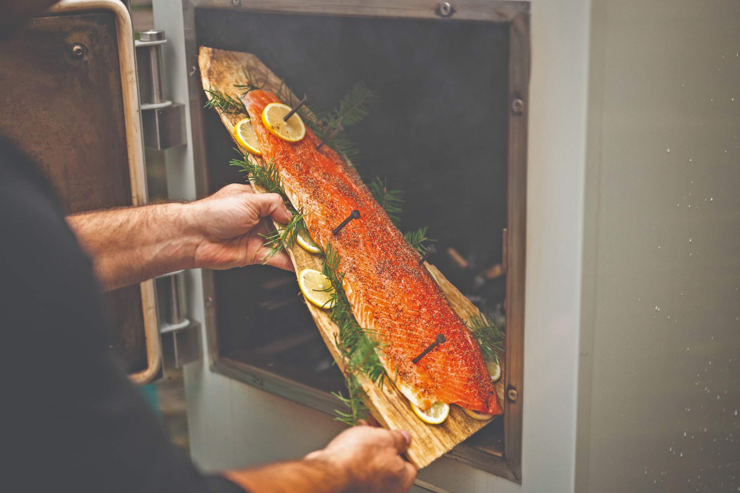 hot smoked salmon placed on a cedar board ready to smoke in the charlie oven