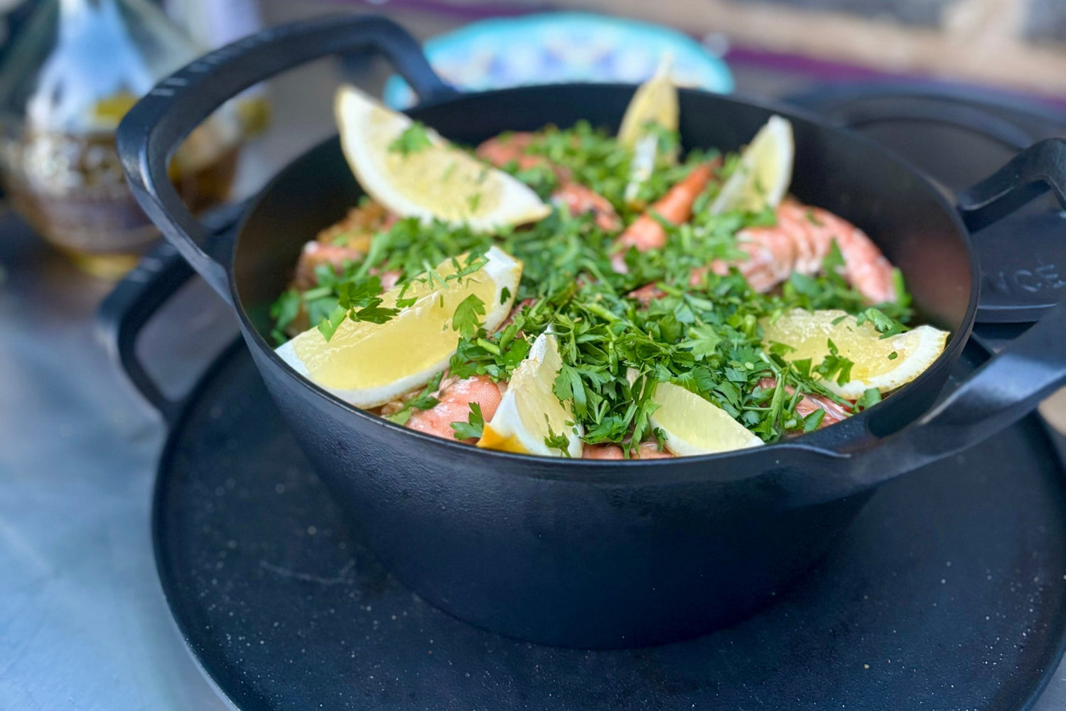 Seafood paella straight out of the charlie oven dressed with lemon slices and fresh parsley.
