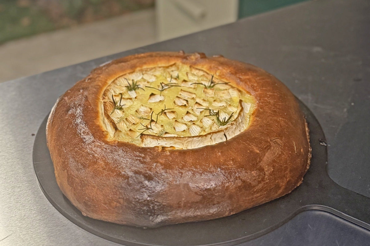 Baked Camembert in a golden brioche bread bowl with garlic and rosemary