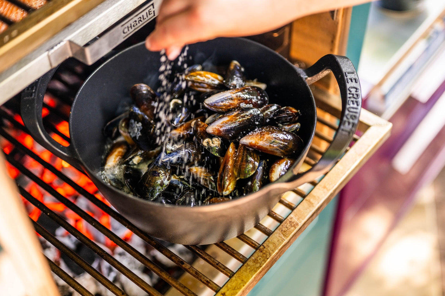 mussles cooked over fire inside the charlie in a cast iron pot