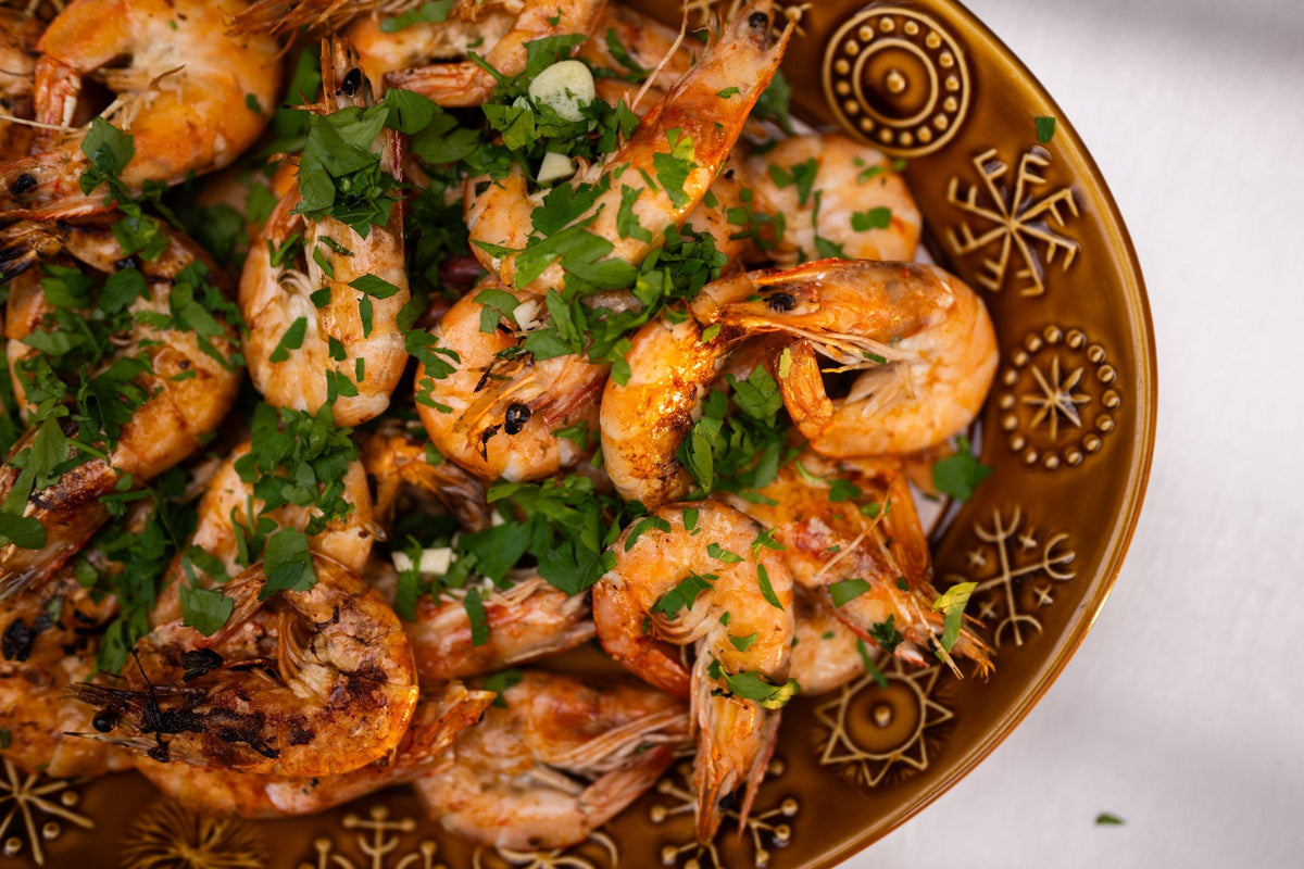 Charcoal grilled shell-on prawns with garlic, chilli and parsley on a plate