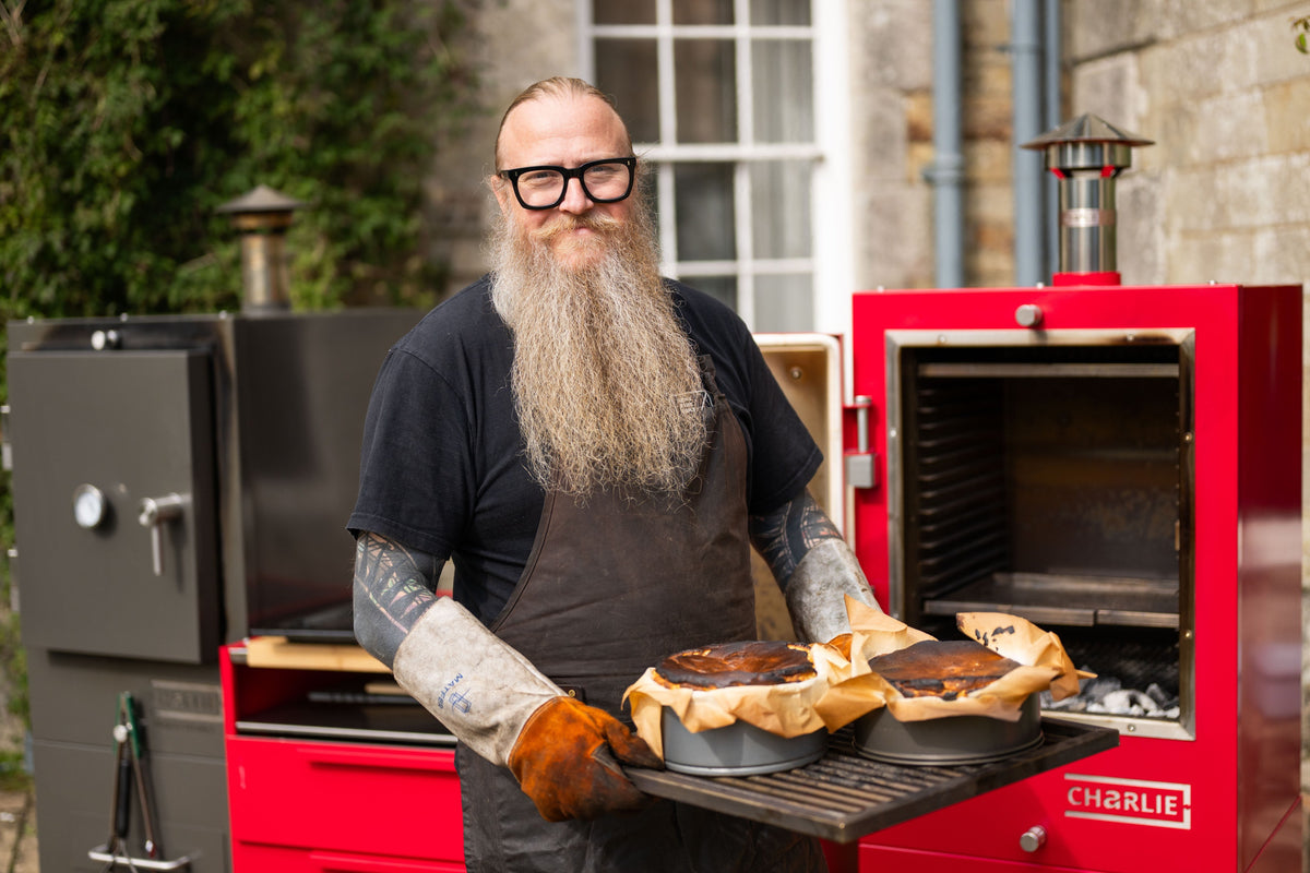 Chef Andrew Clarke lifting freshly baked dishes from a Charlie Oven