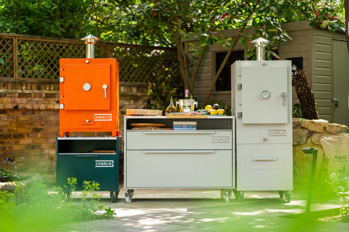 Two roast chickens coming out of a Charlie charcoal oven.