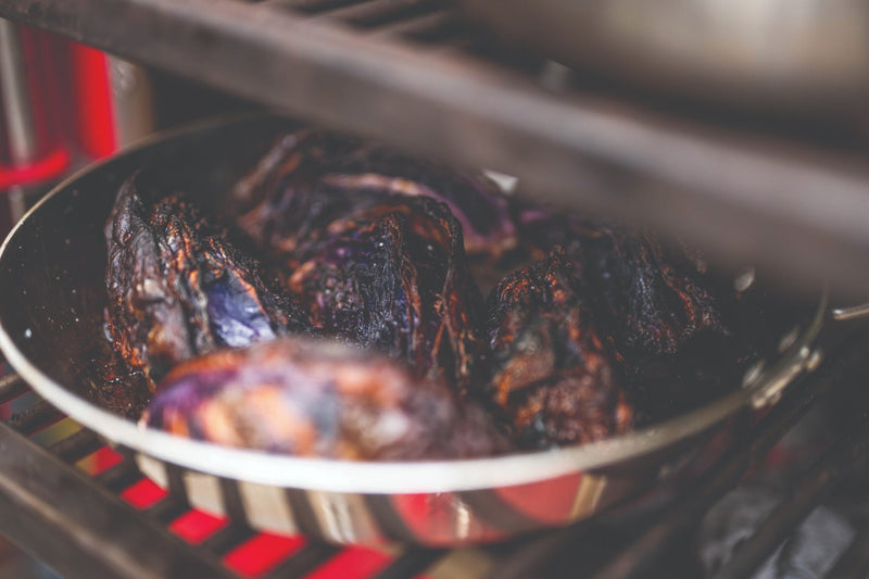 Red cabbage charring in a pan on the lowest level, just above the charcoal