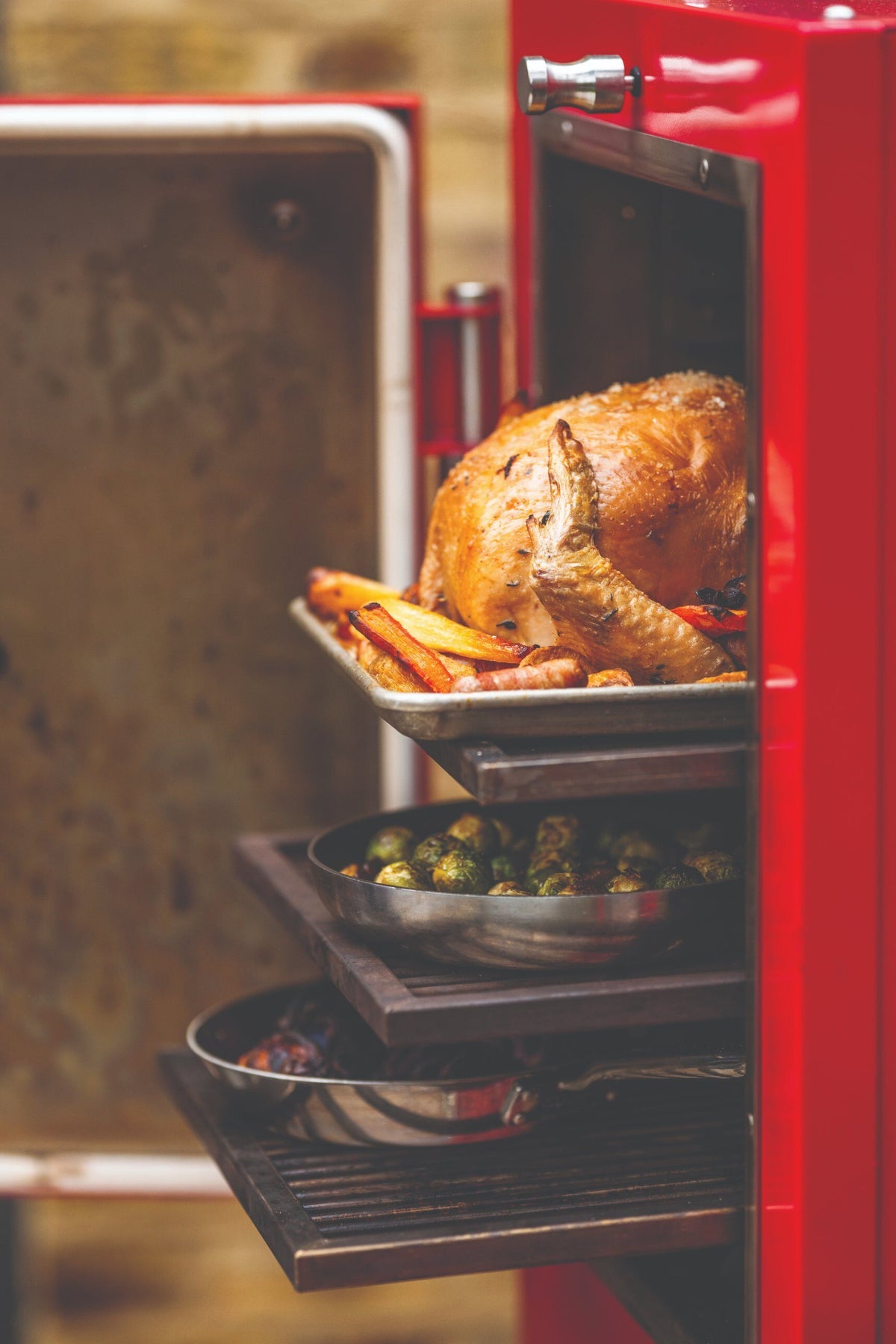 Christmas turkey roasting above sprouts and red cabbage in a Charlie charcoal oven