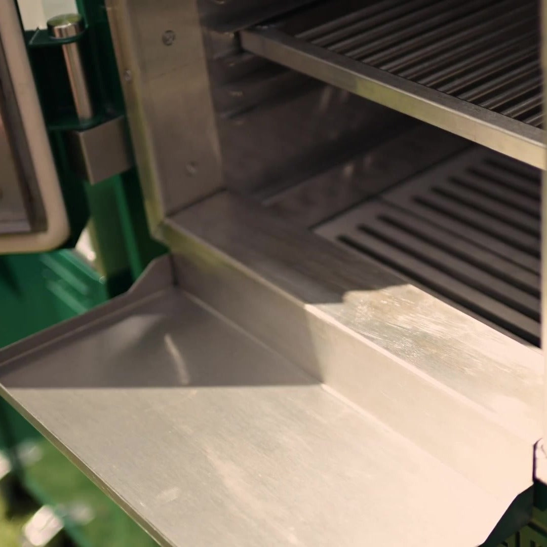 Close-up of the Charlie Oven drip tray clipped across the lip of the open oven door