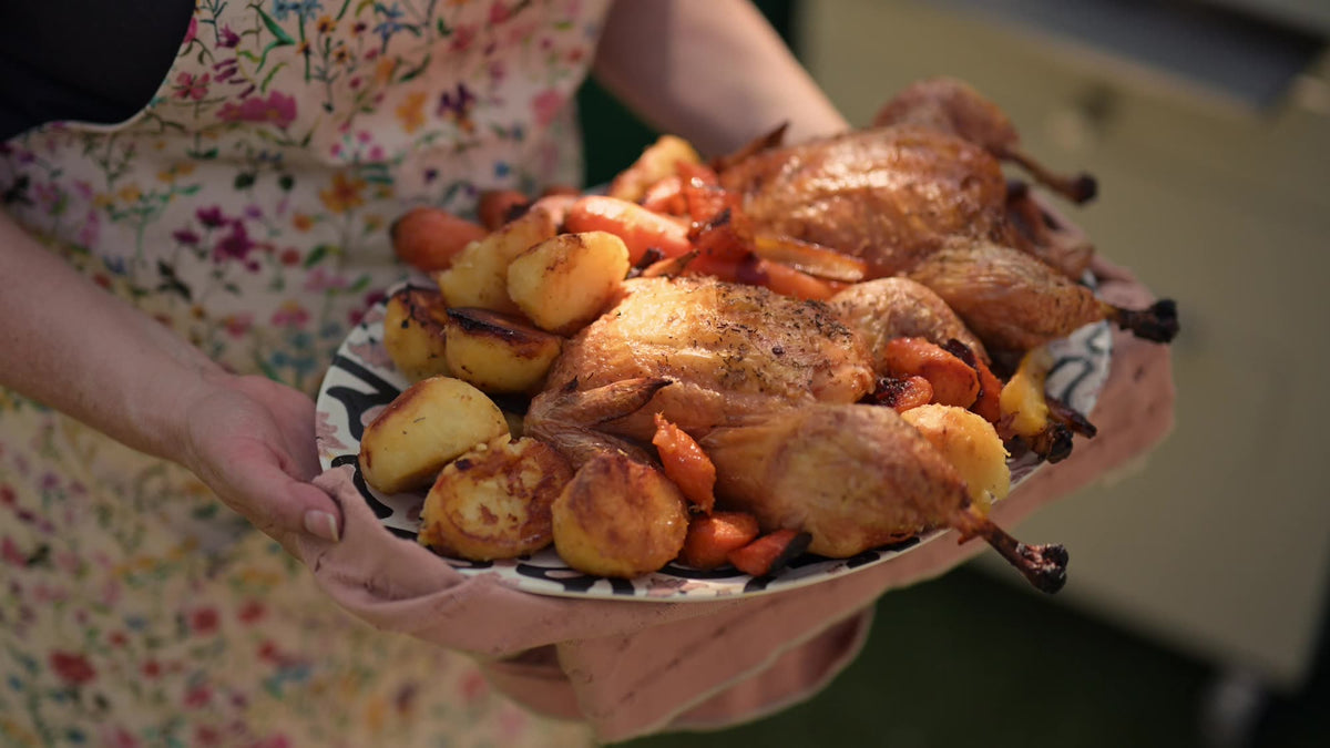A platter of roast chicken, potatoes and carrots