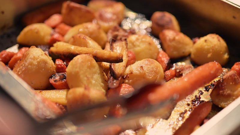 Roast potatoes and carrots glossy with chicken juices