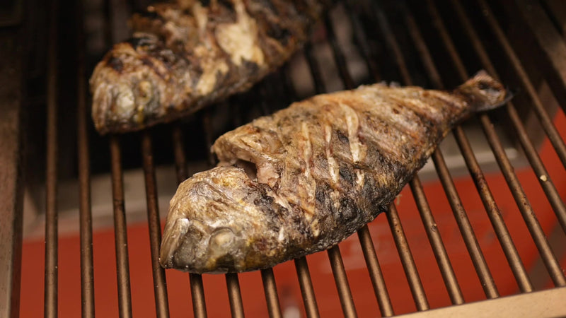 Whole sea bream with crisp, charred skin on the grill rack