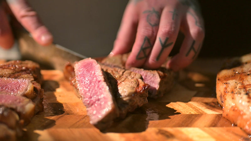 Slicing a charcoal grilled steak on a board
