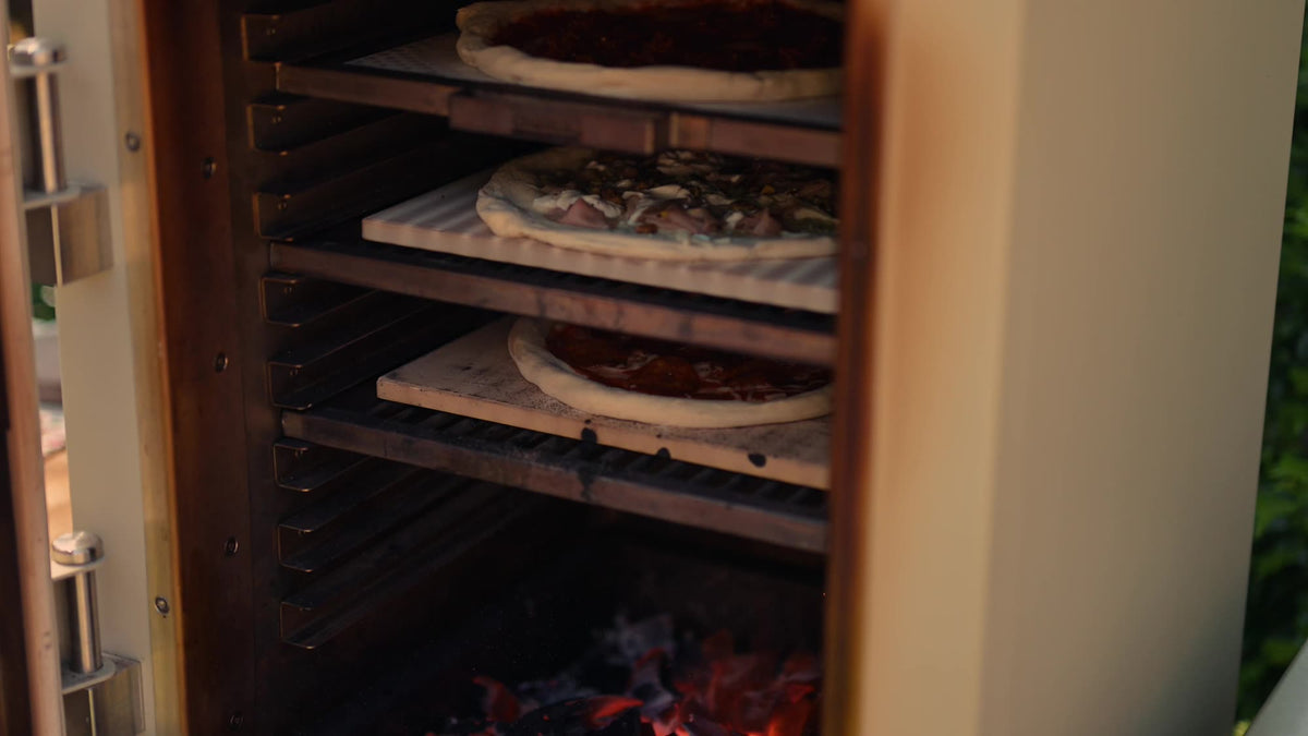 Three pizzas baking on stones in the Charlie oven