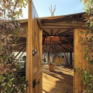 Wooden doors opening into the tipi in the garden at Trindle Stores, Kew