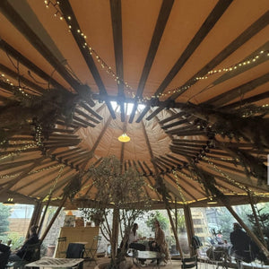 Inside the tipi in Trindle’s secret garden in Kew, strung with fairy lights and winter greenery
