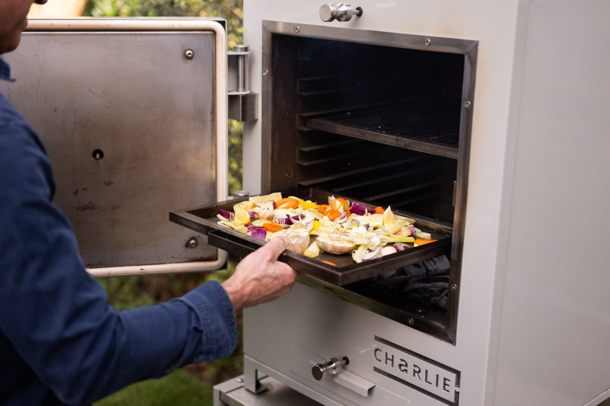 A tray of vegetables going into a Charlie charcoal oven